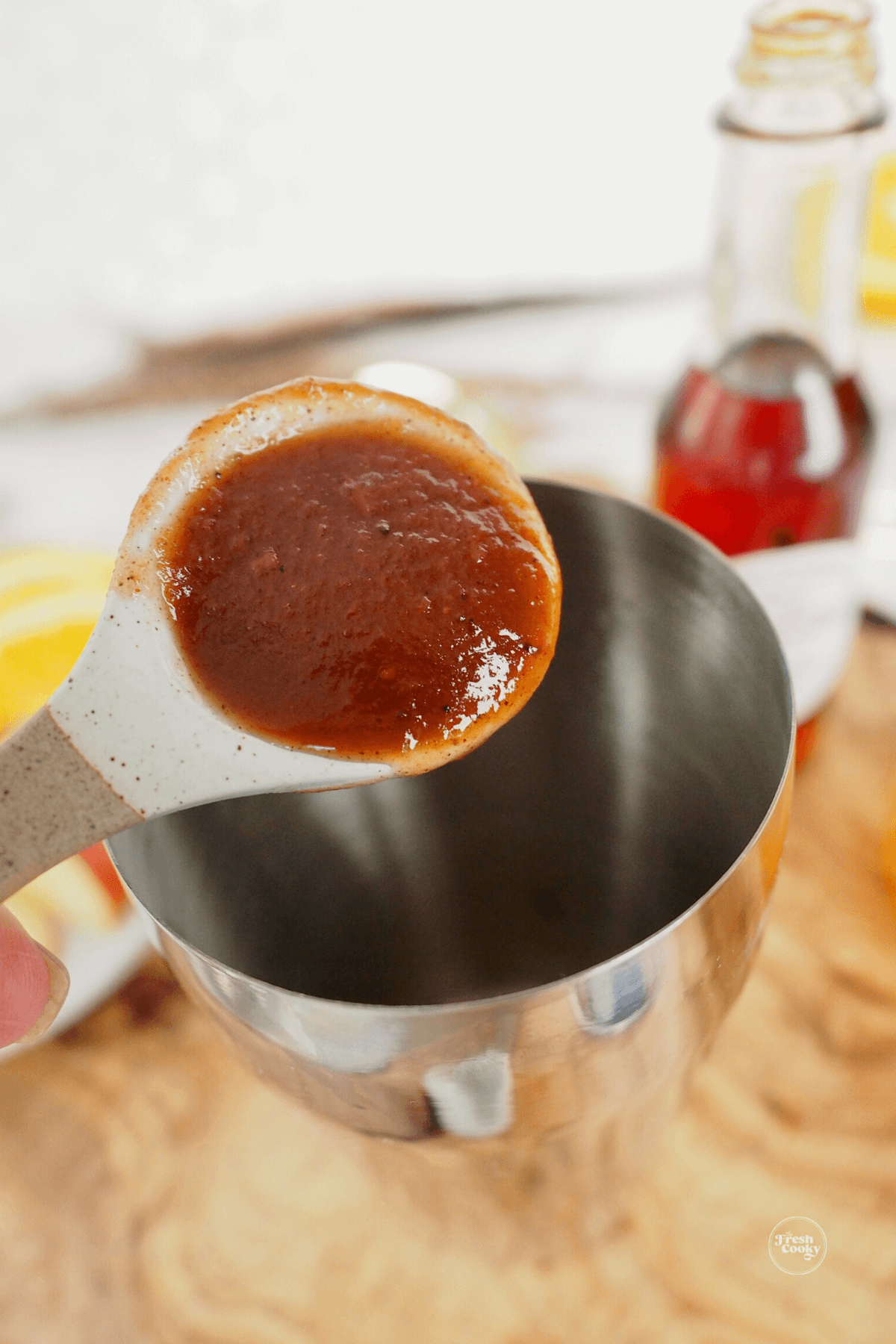 Adding apple butter to cocktail shaker. 
