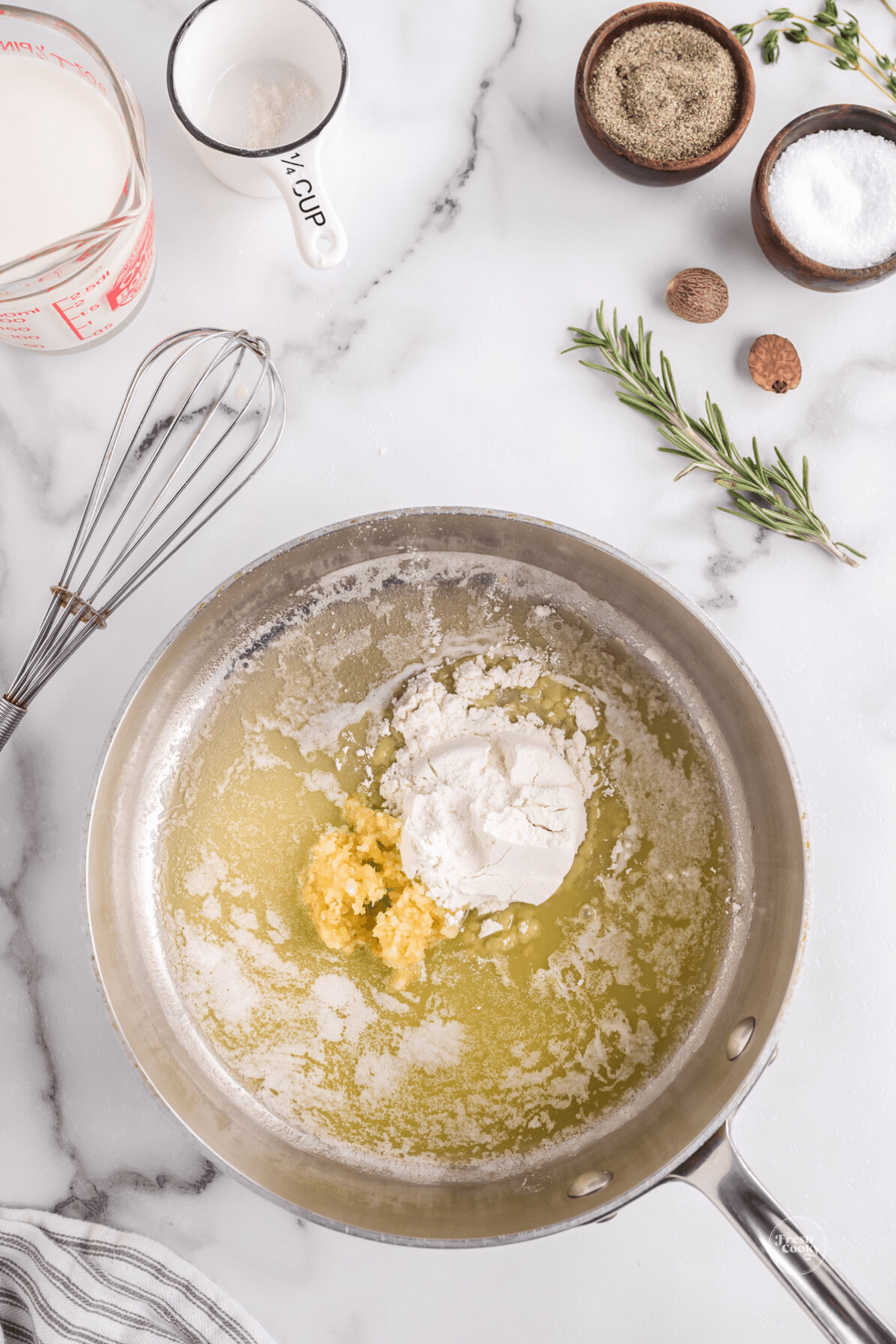 Adding flour and garlic to melted butter for a roux. 