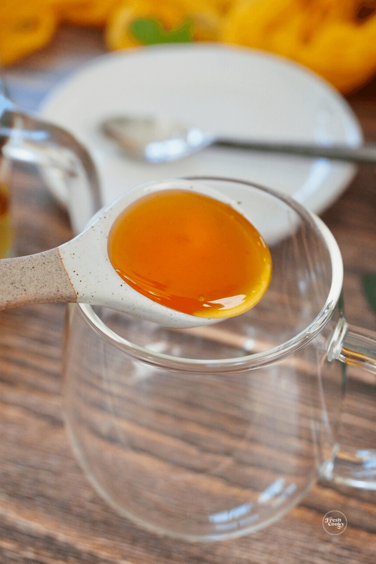 Adding honey to a mug for medicine tea ball. 