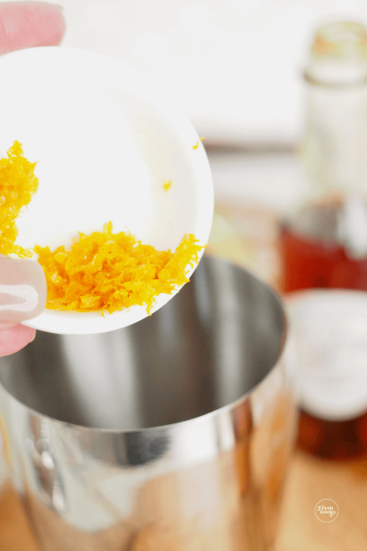 Adding orange zest to shaker. 