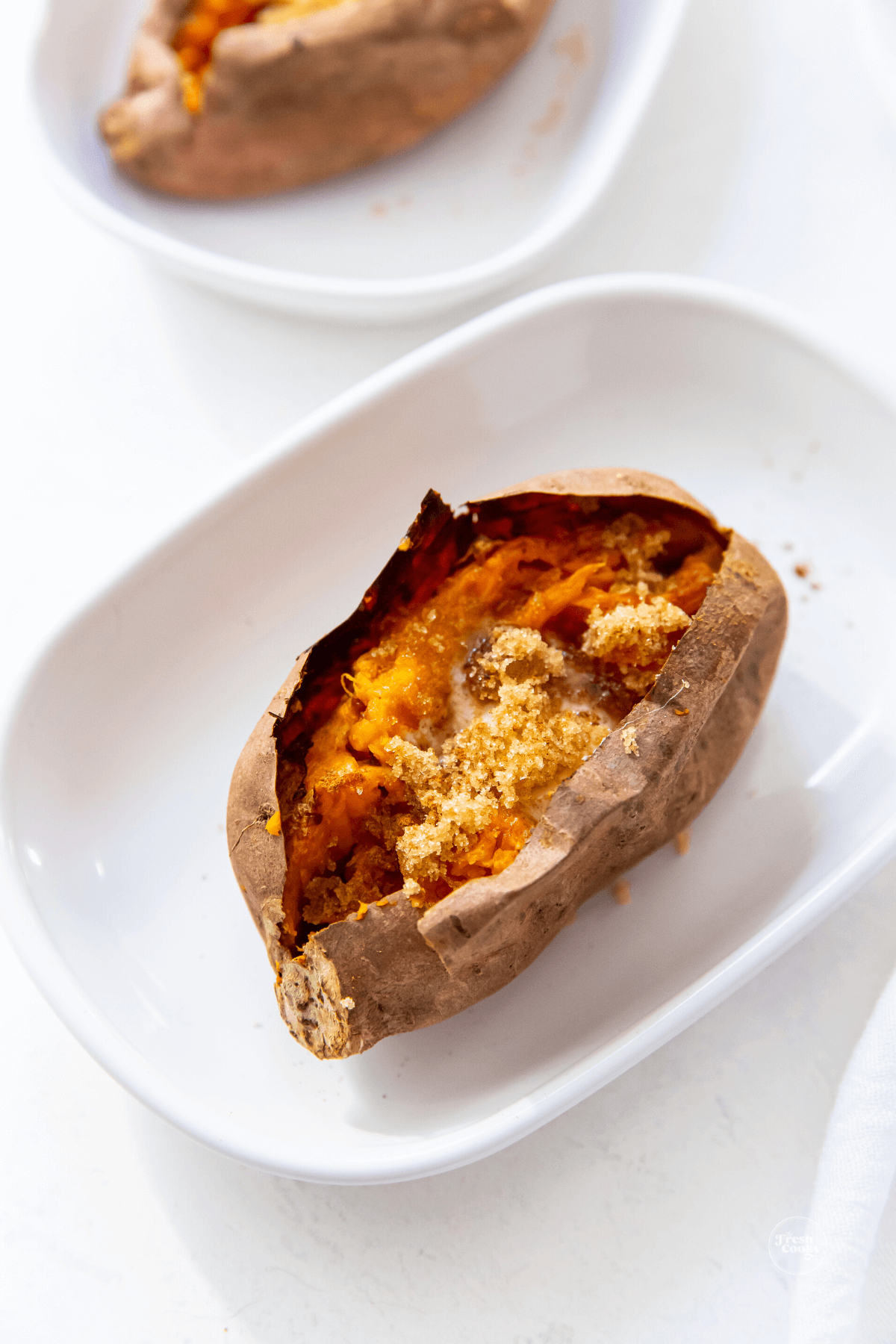 Baked sweet potato on ceramic plate.