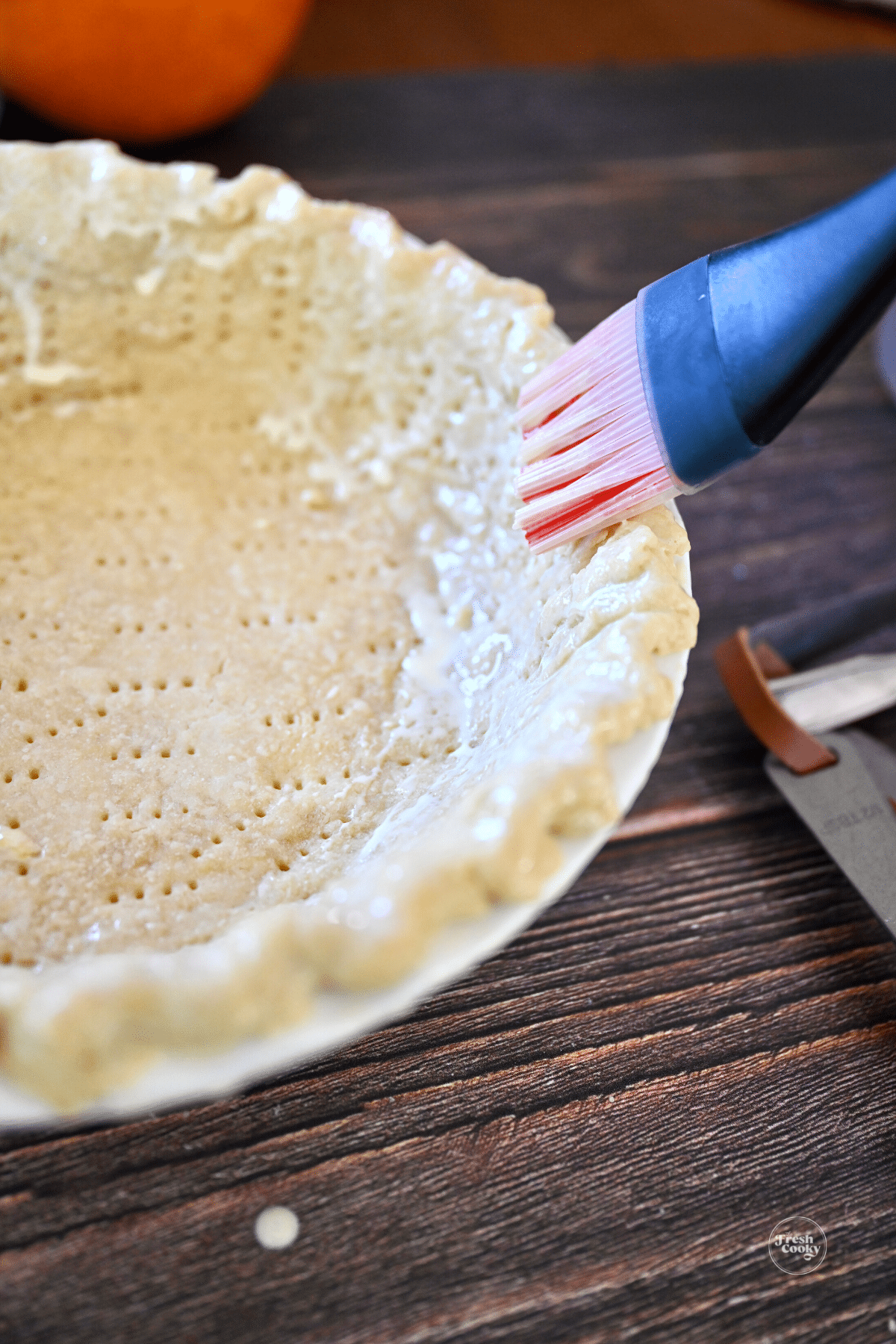 Brushing pie dough with egg wash.