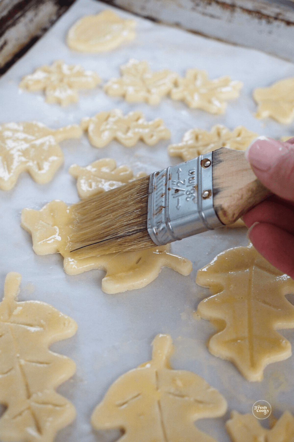 Brushing leaves with egg wash.