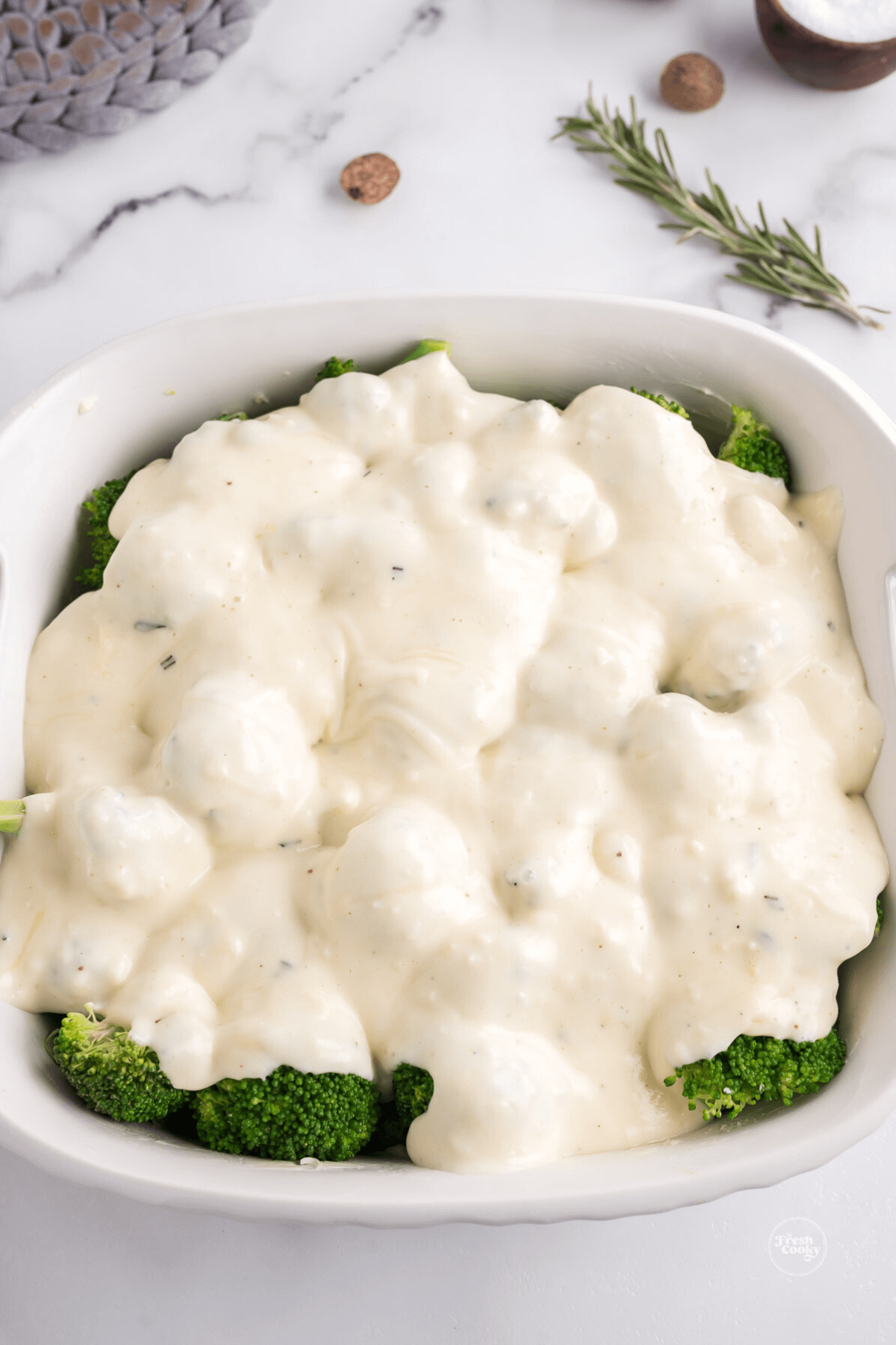 White sauce bechamel poured over steamed broccoli. 