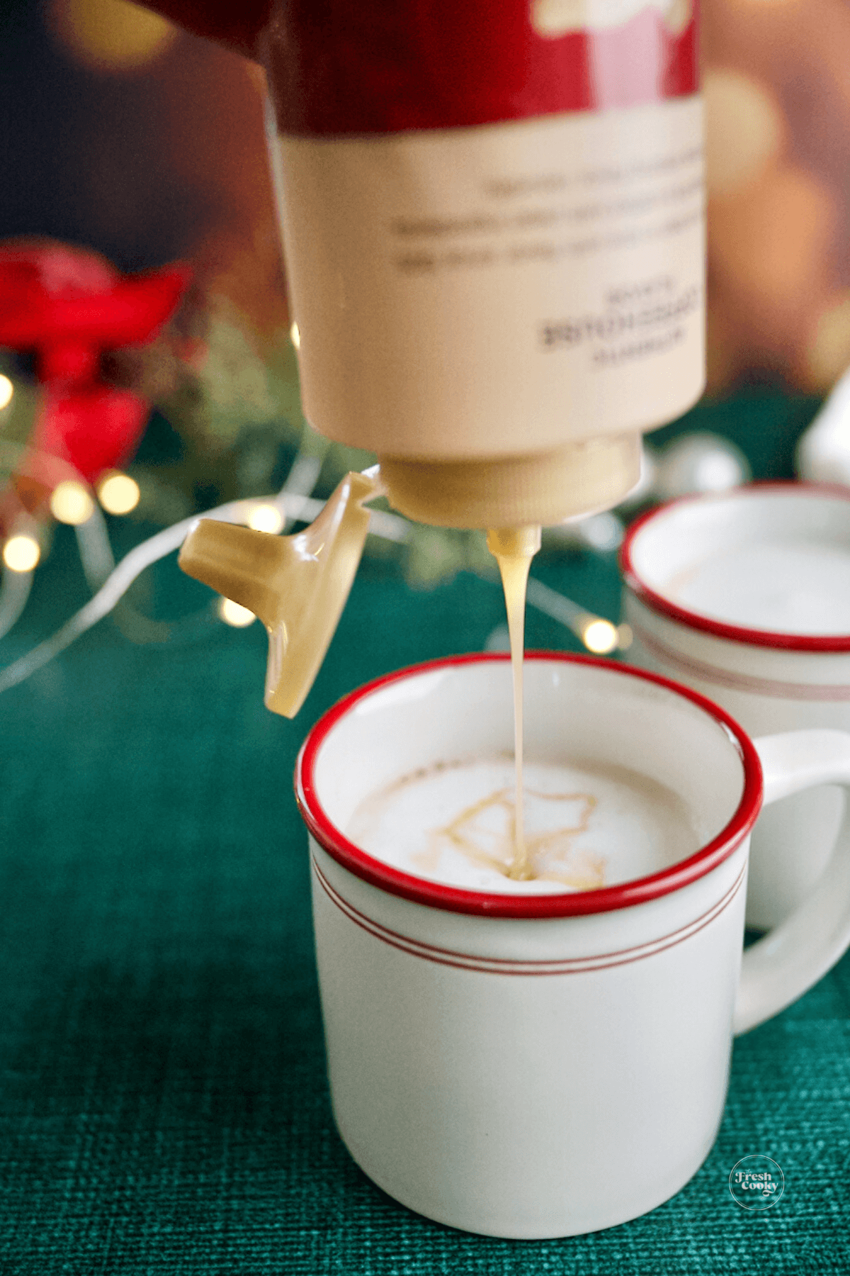 Pouring in some white chocolate syrup to mug of hot chai. 