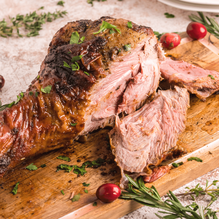 Air Fryer Turkey leg on cutting board with a few slices removed.