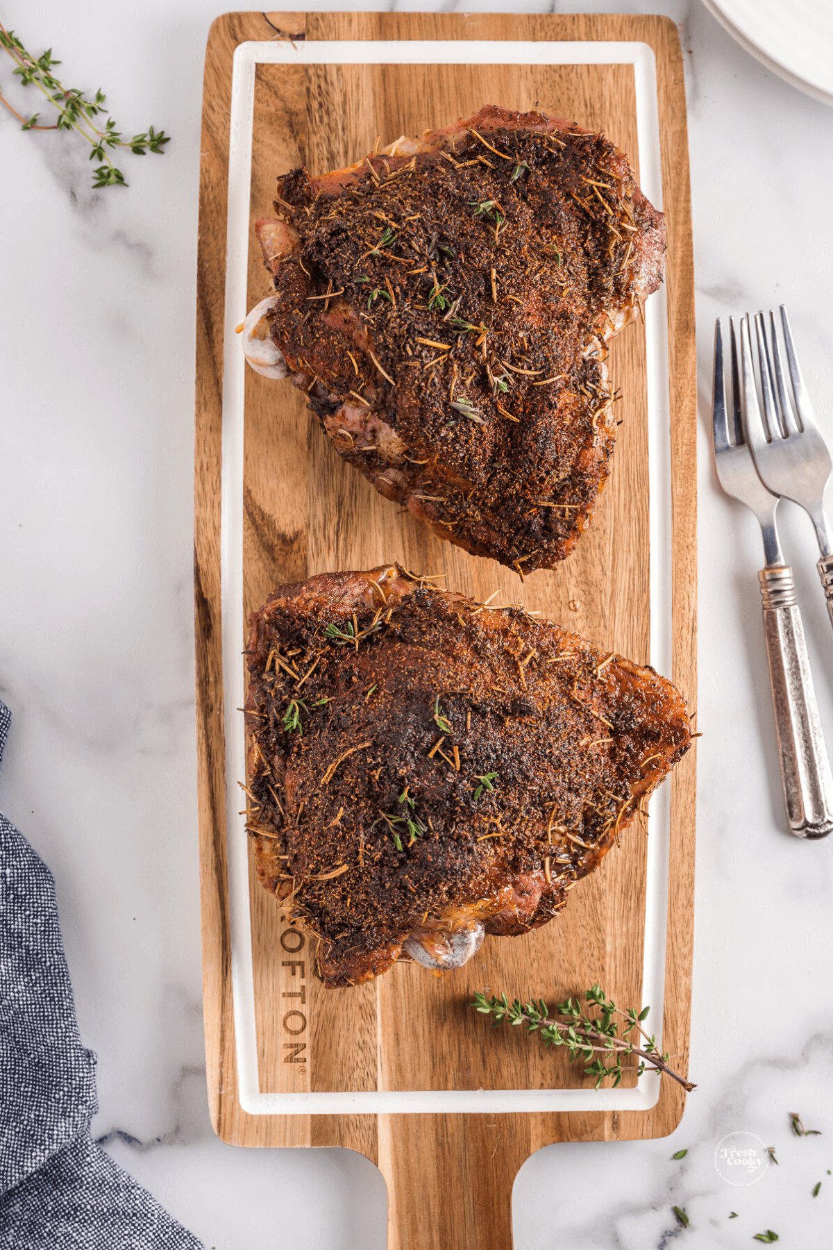 Air fryer turkey thighs on cutting board.