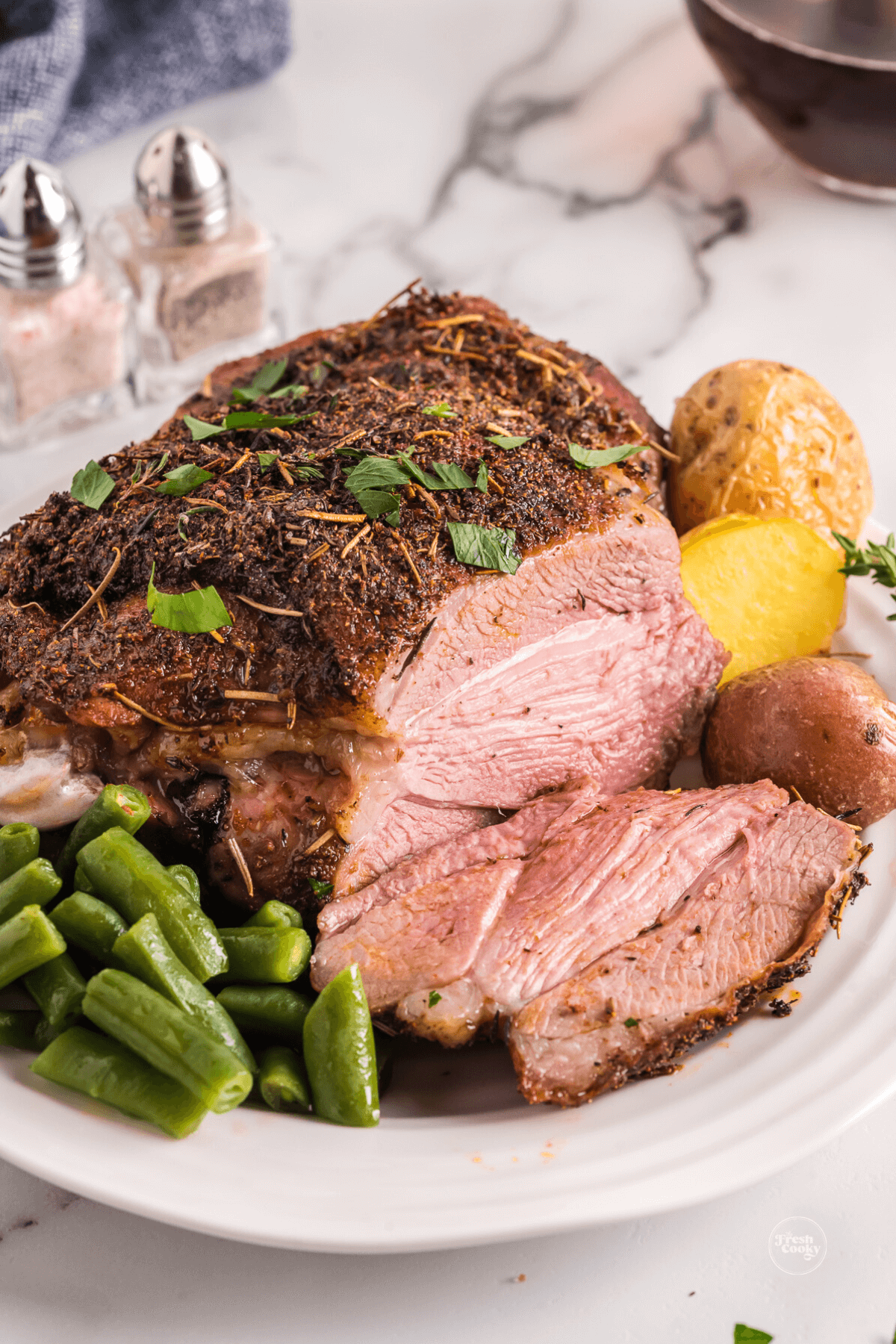 Sliced air fryer turkey thigh on plate with juices running out.