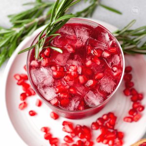 Top down view of a Christmas margarita garnished with fresh pomegranate arils and a sprig of fresh rosemary for a beautiful Christmas drink.