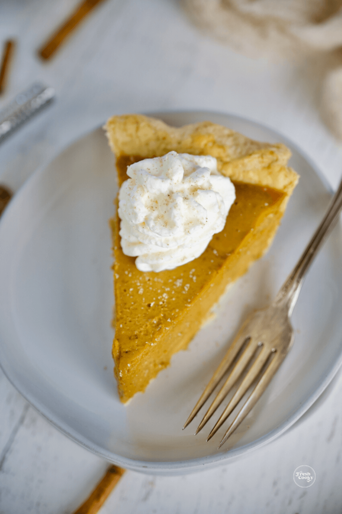 Slice of pumpkin custard pie with whipped cream.