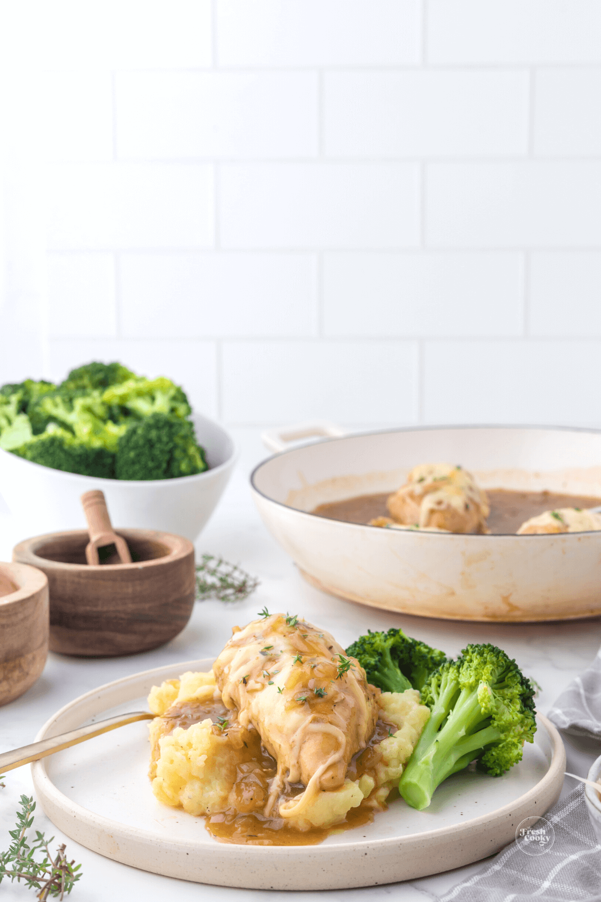 French Onion chicken dinner with skillet in background and broccoli.