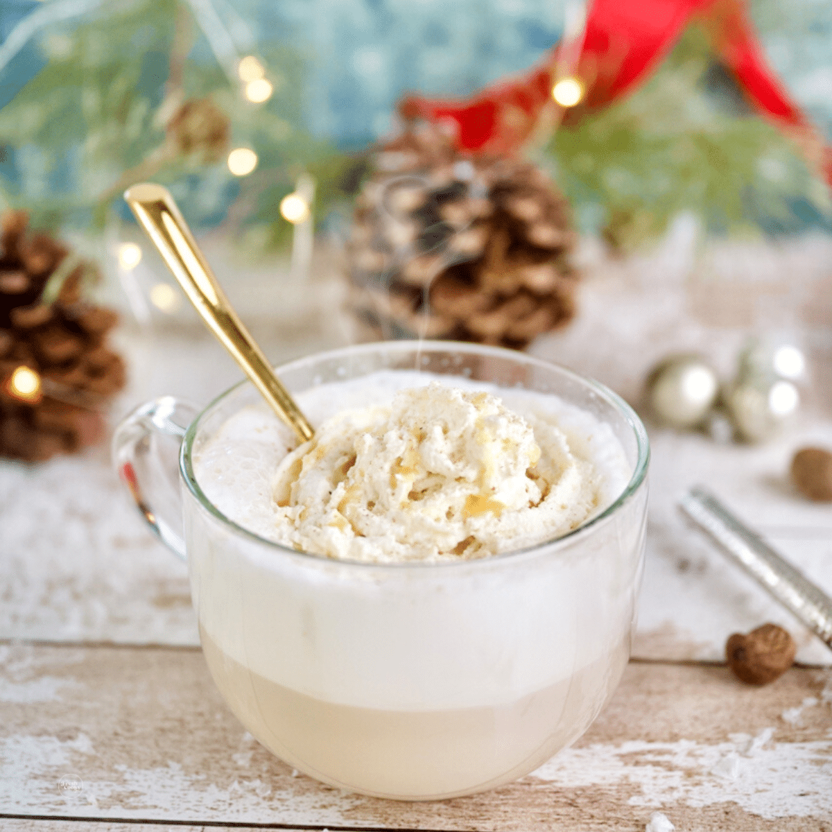 Hot Christmas Morning Copycat Chai Latte in mug with whipped cream and a gold spoon.