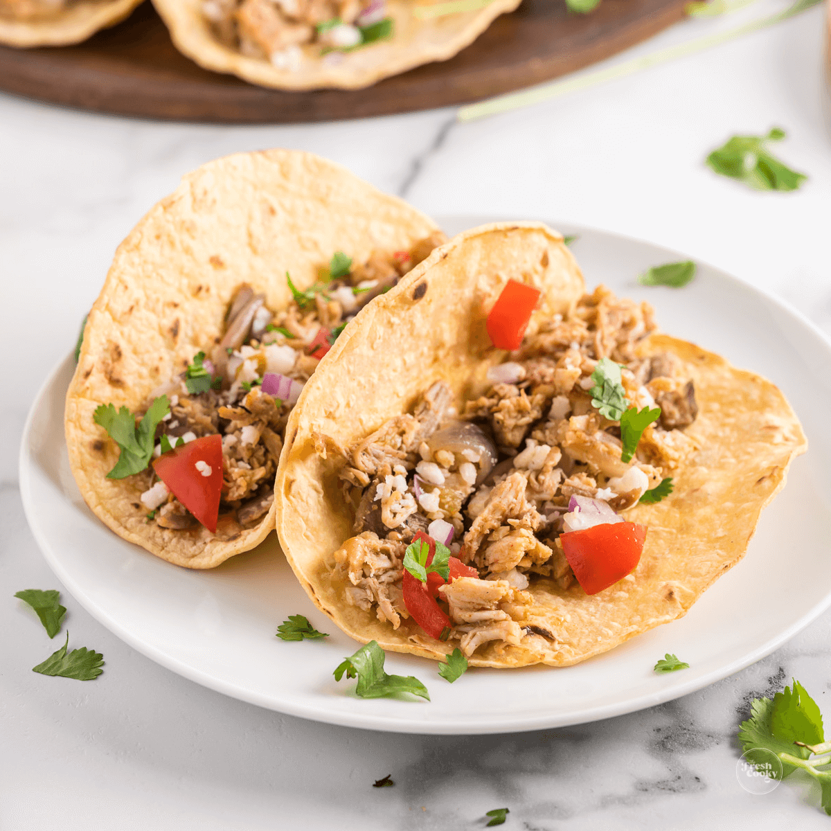 Leftover Turkey Tacos on plate with toppings and cheese.