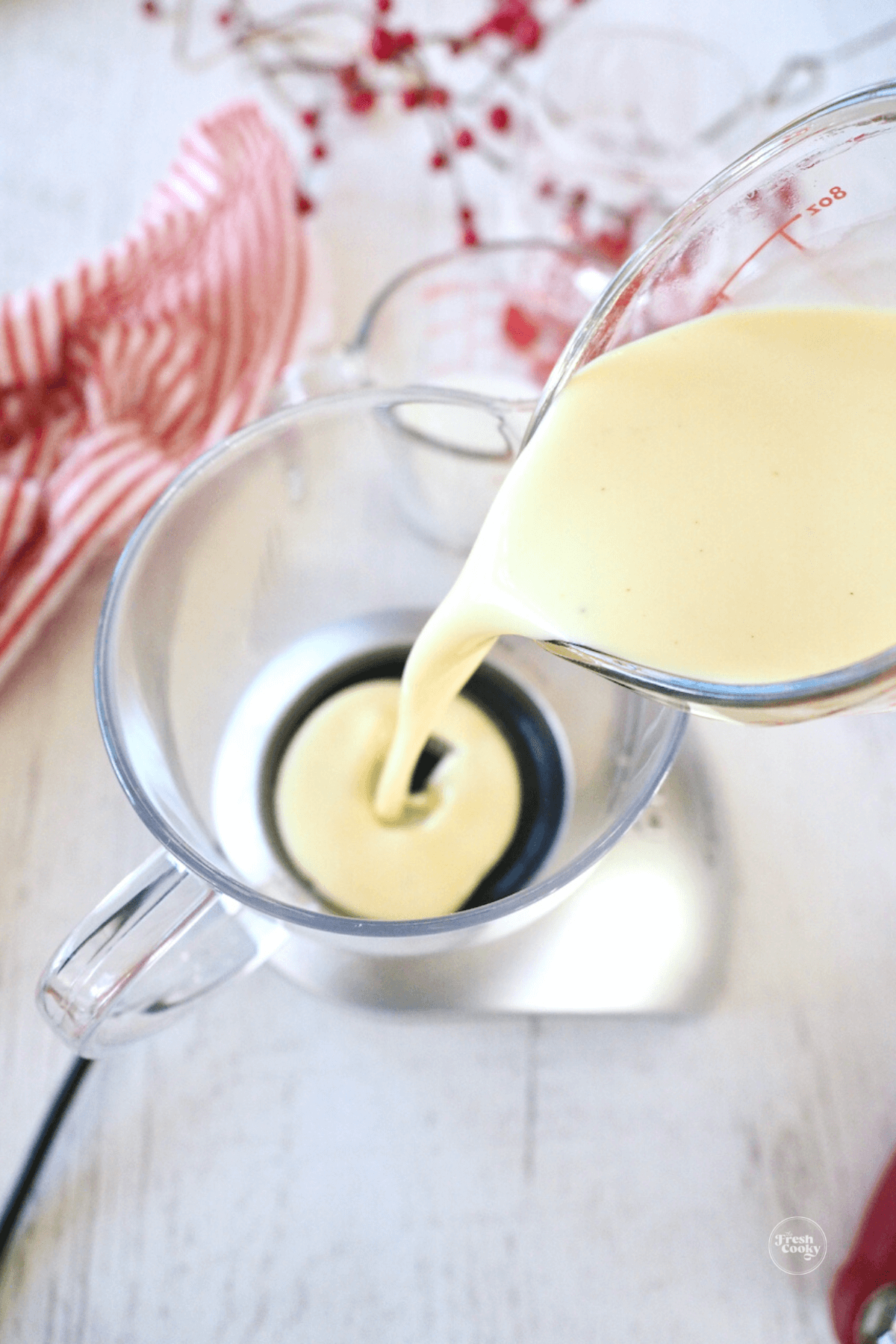 Pouring eggnog into frother for eggnog latte.