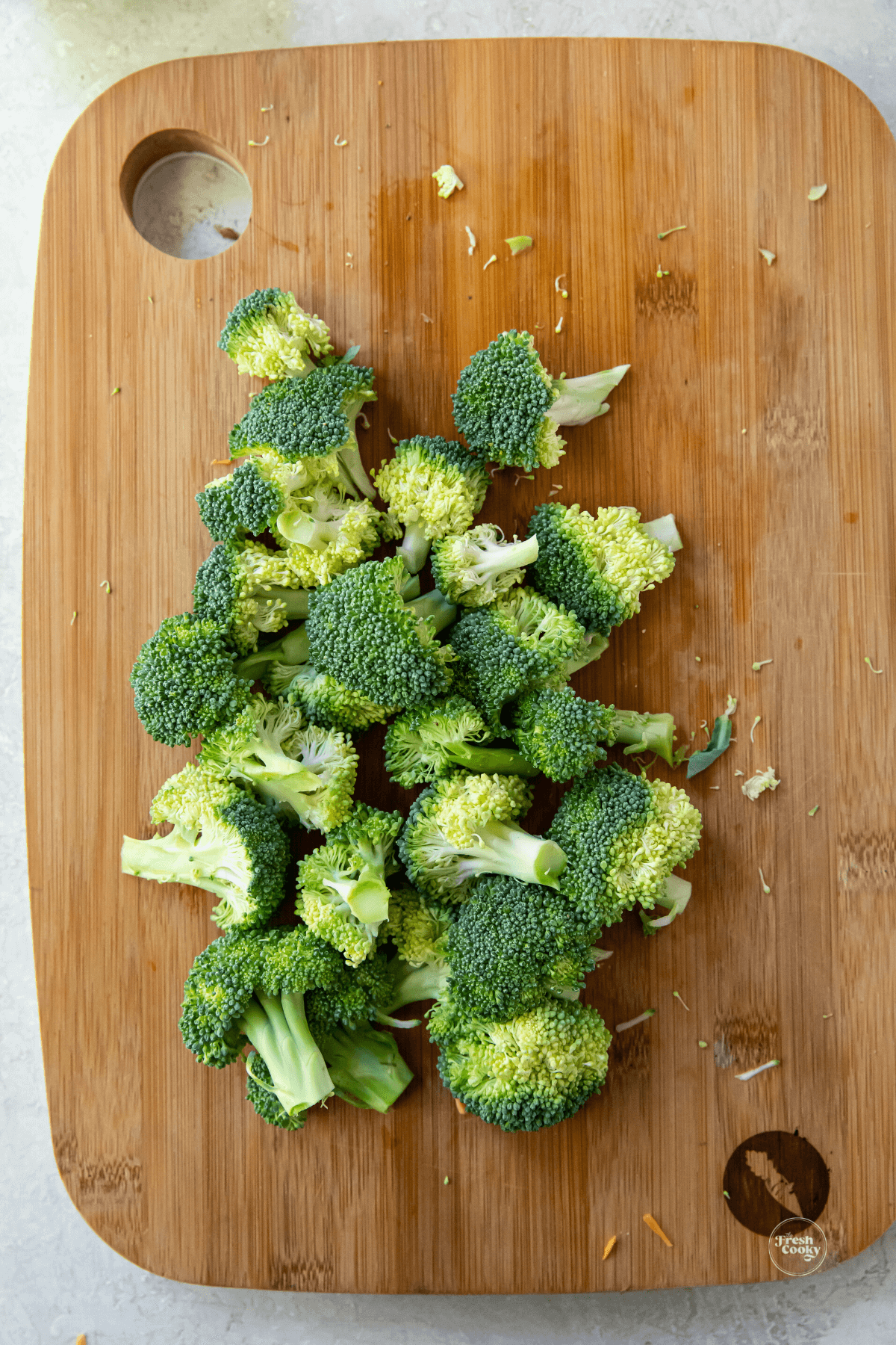 Broccoli florets cut on cutting board.