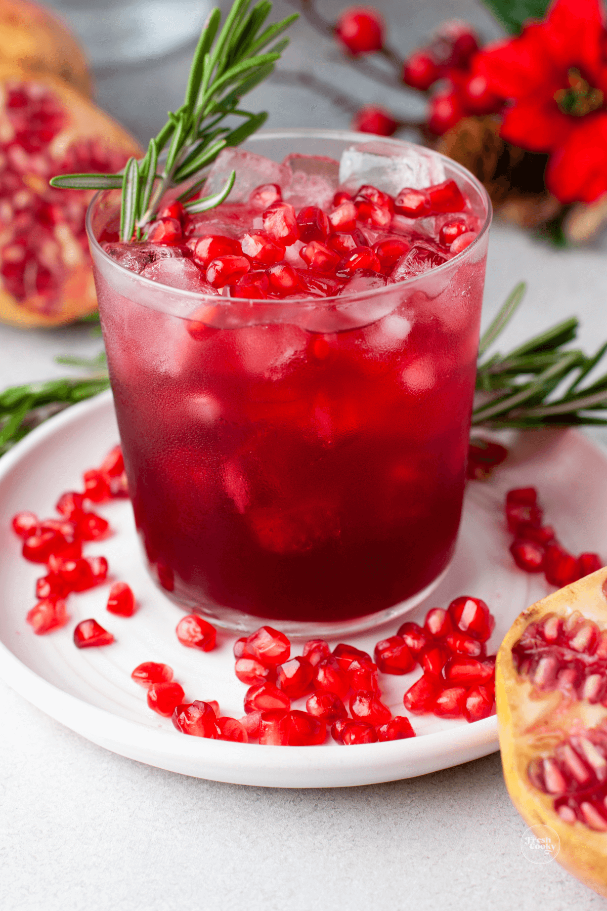 Hibiscus Pomegranate Margarita Recipe in glass garnished with rosemary and fresh pomegranate arils. 