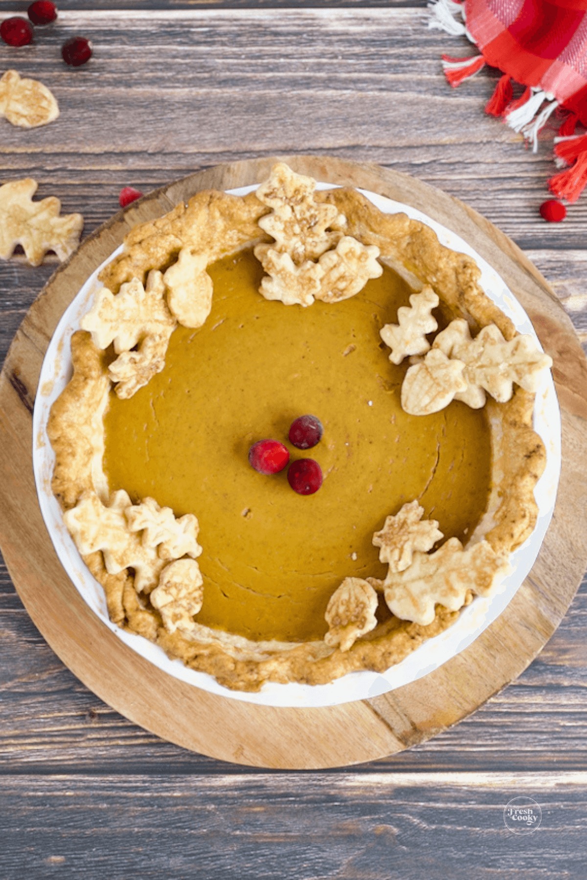 Decorated pumpkin custard pie with pastry leaves.