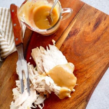 Turkey giblet gravy in measuring cup and poured over turkey breast.