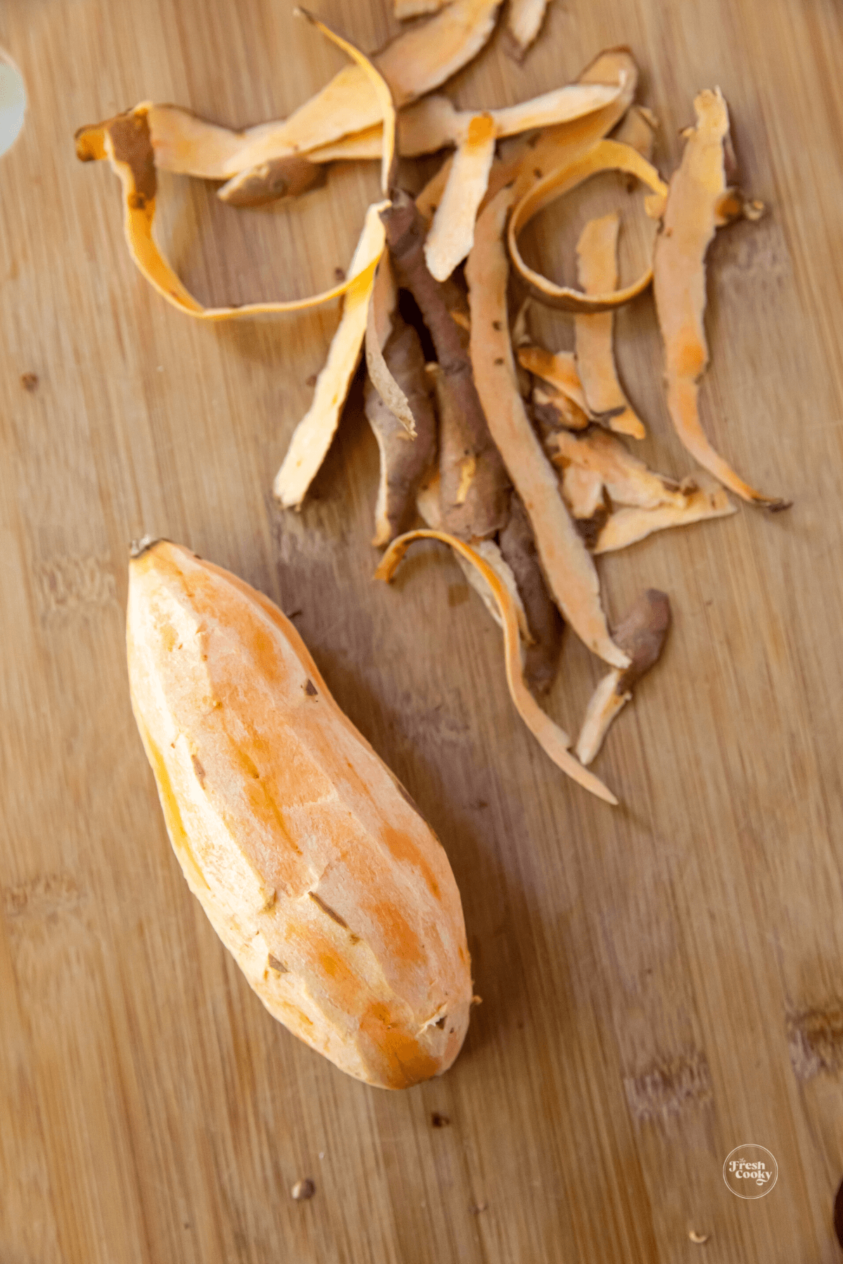 Peeled sweet potato on cutting board.