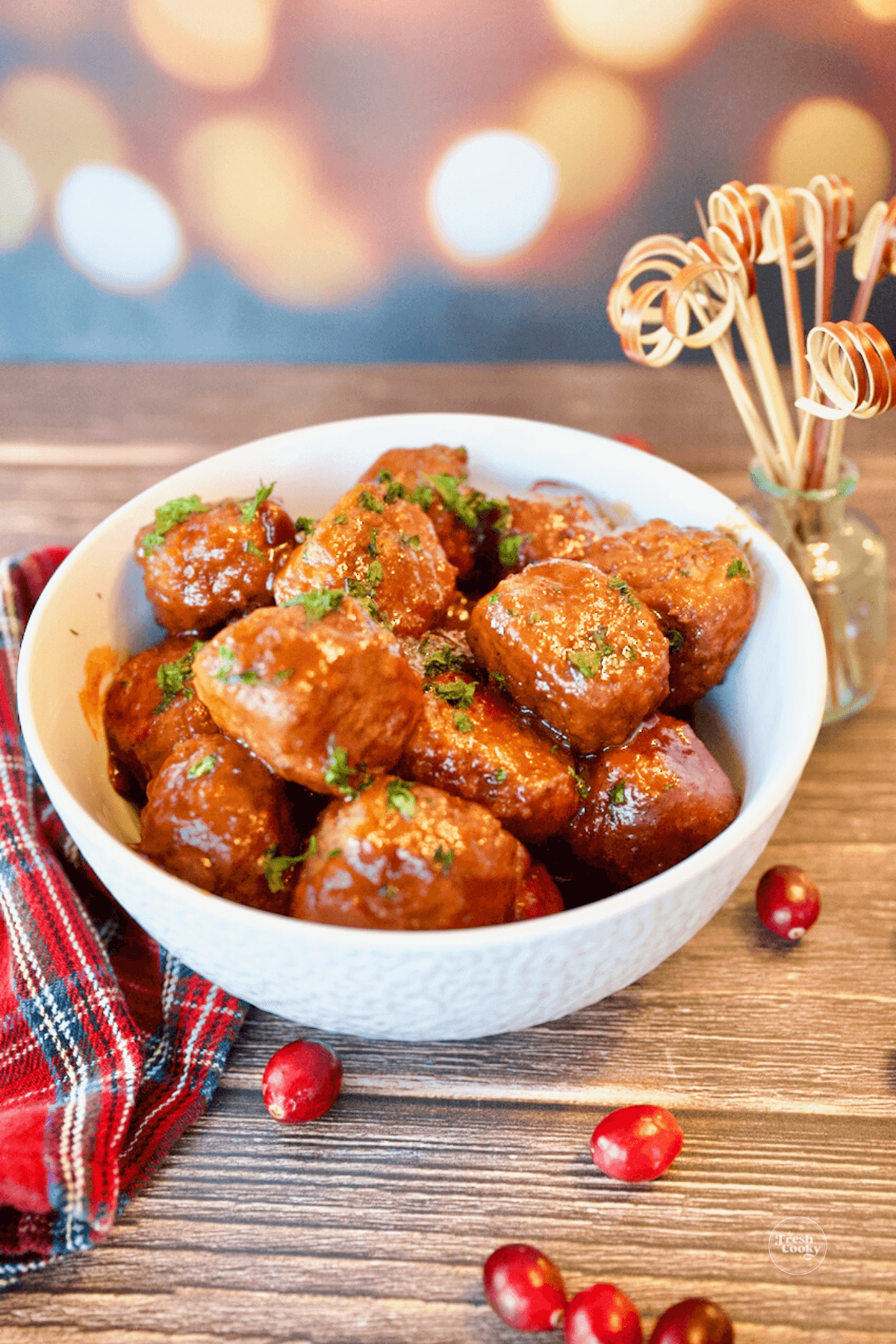 Cranberry Meatballs in serving bowl with wooden skewers for eating.