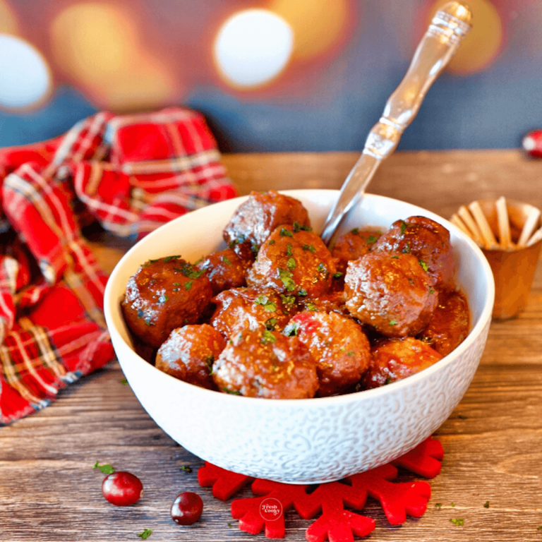 Cranberry Meatballs in bowl with serving spoon and toothpicks for cocktail parties.