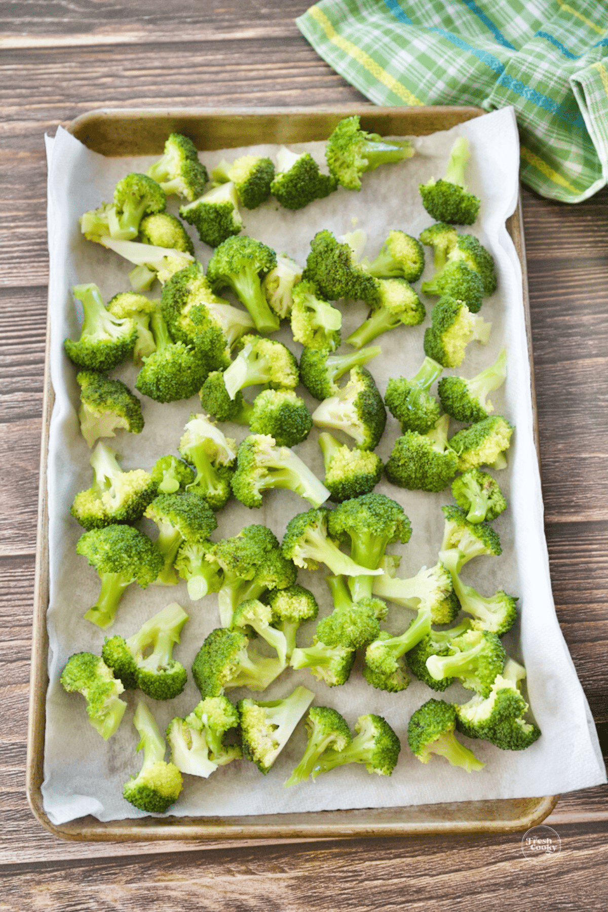 Blanched broccoli in tray with paper towels to absorb water.