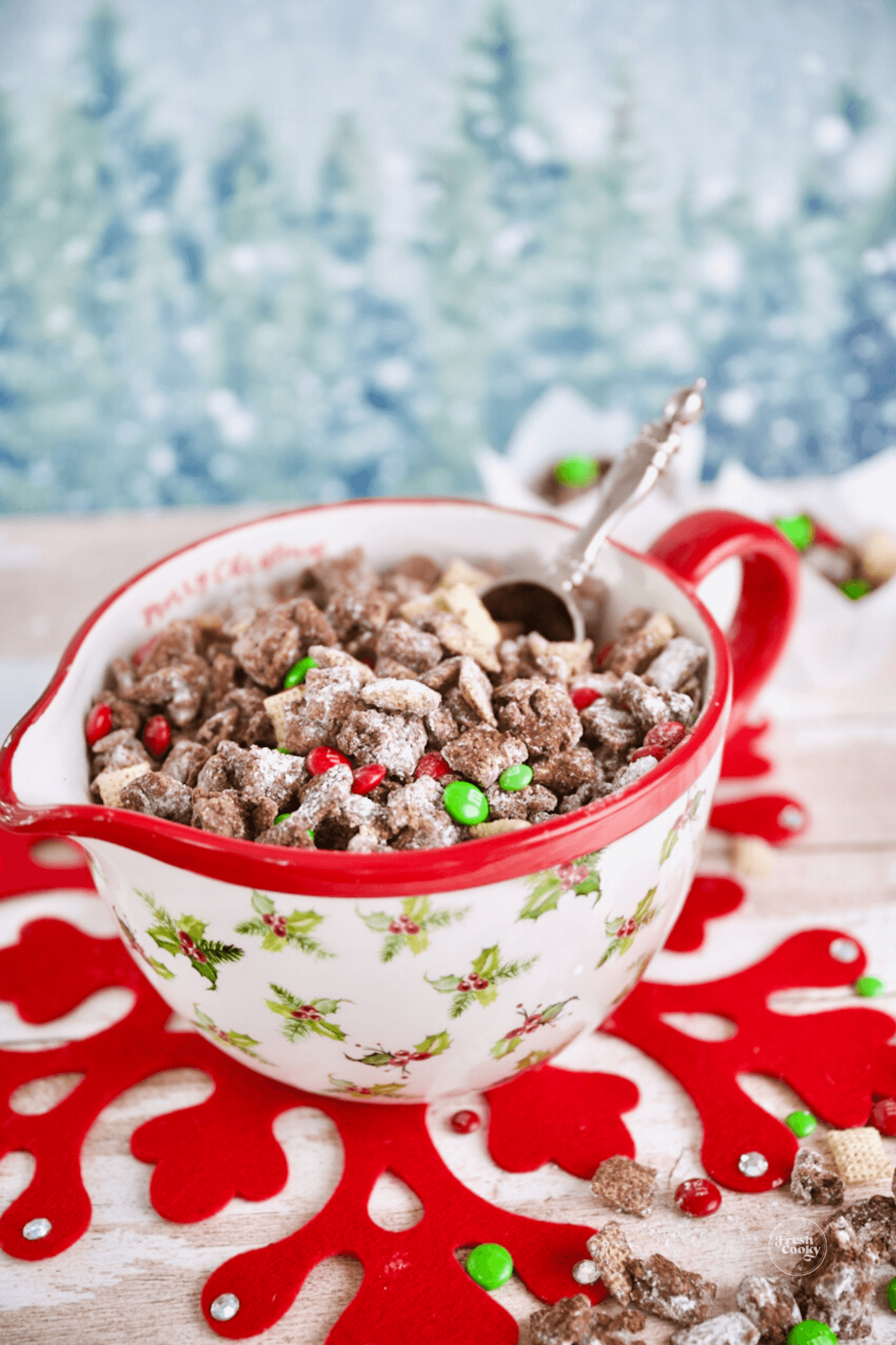 Christmas bowl filled with Reindeer Chex Mix with servings in paper cupcake liners, serving suggestion.