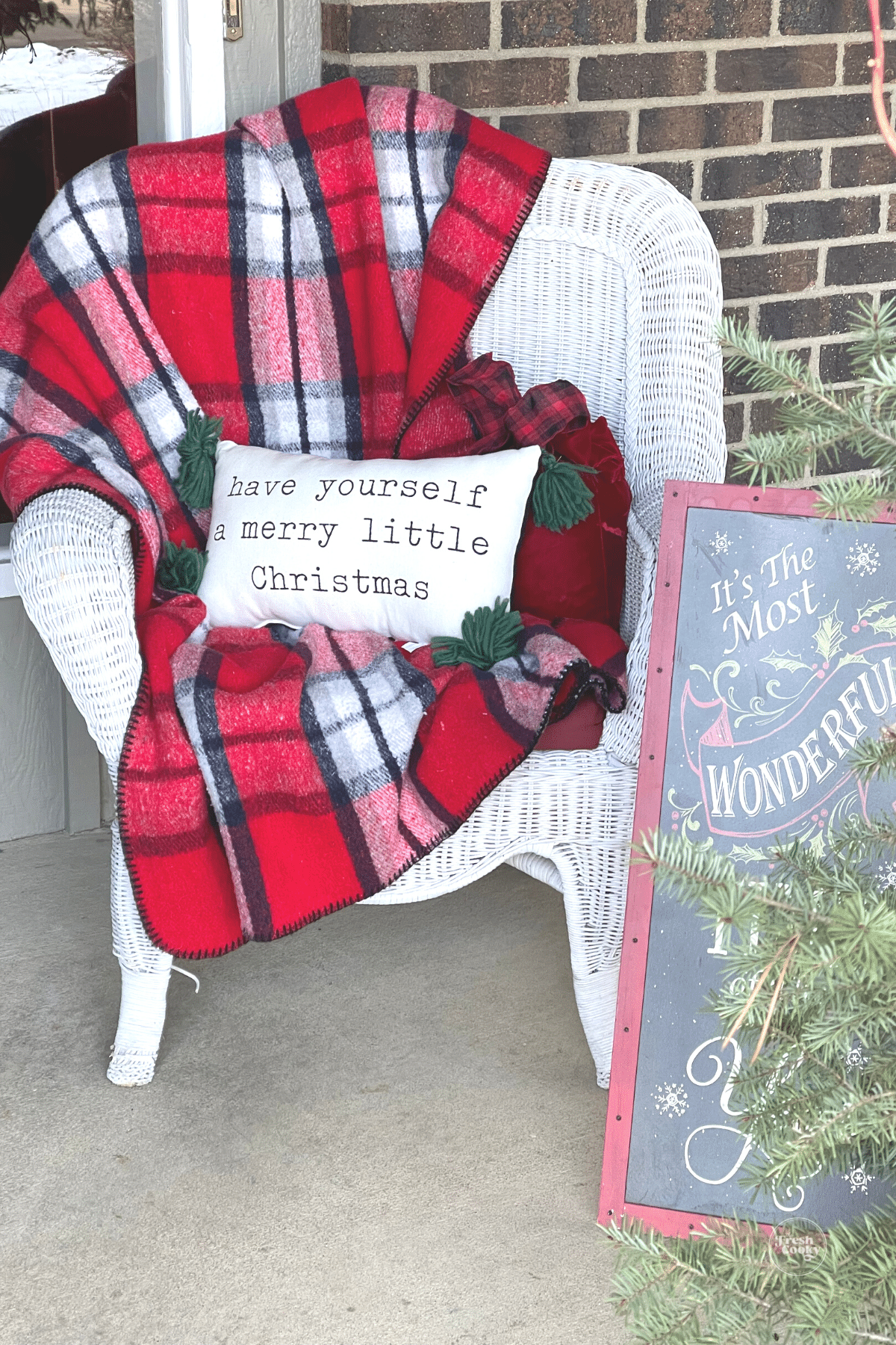 Chair decorated for Christmas and sign welcoming all who gather here.