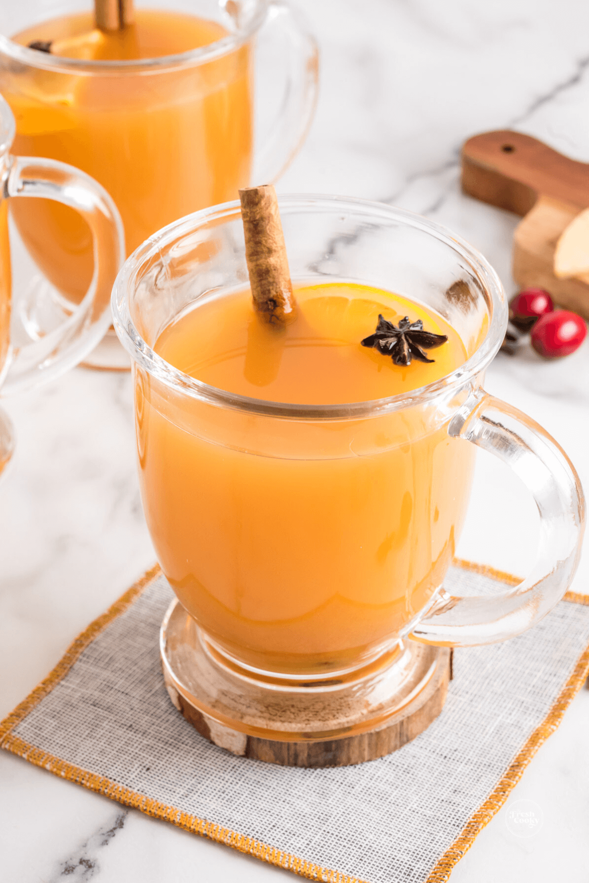 Delicious traditional wassail recipe non-alcoholic in a glass mug with cinnamon stick and star anise.