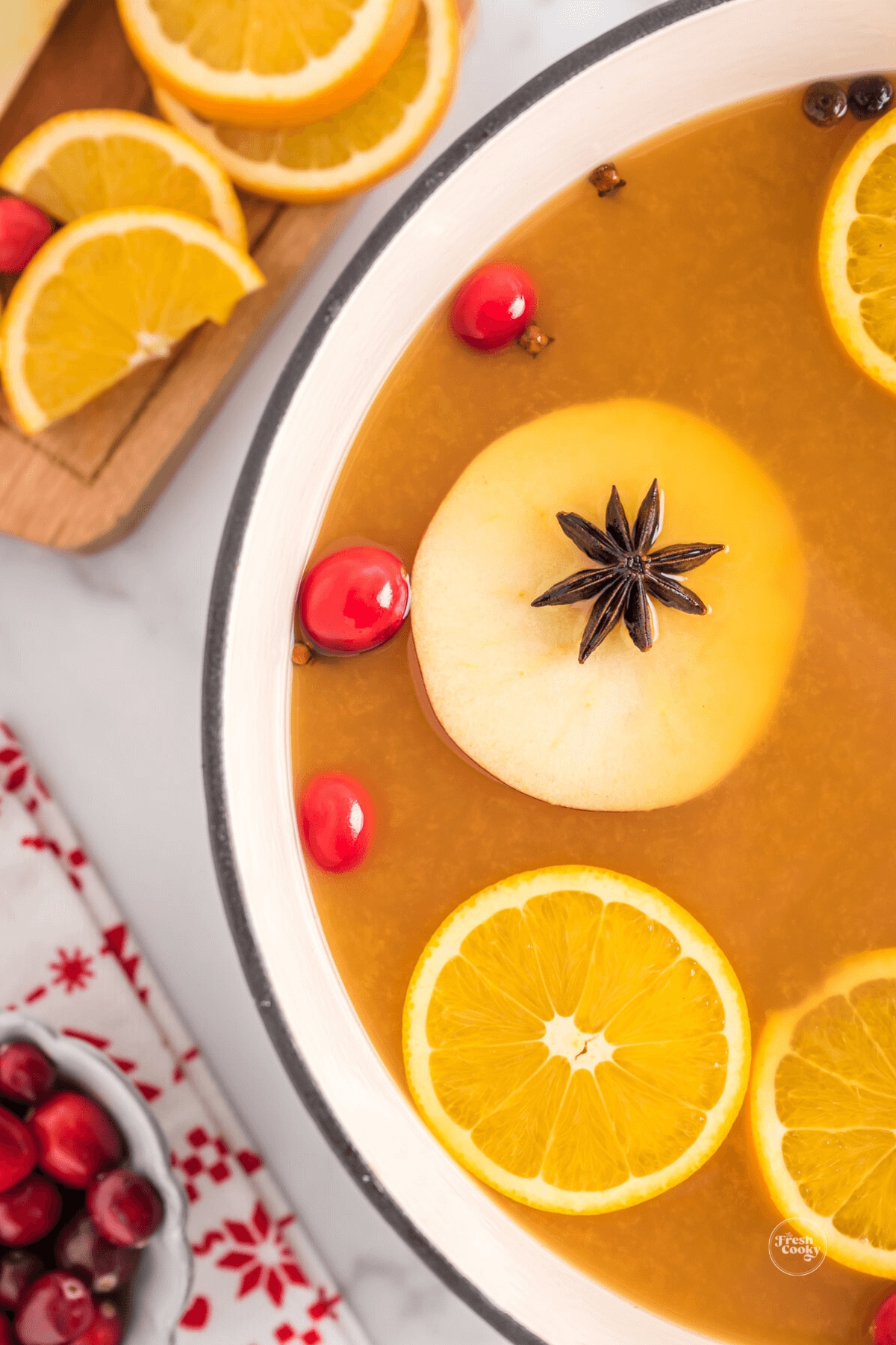 Easy wassail recipe non-alcoholic in a pretty pot, heated and ready to serve.