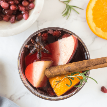 Glass filled with spiced holiday sangria with red wine and fruit.
