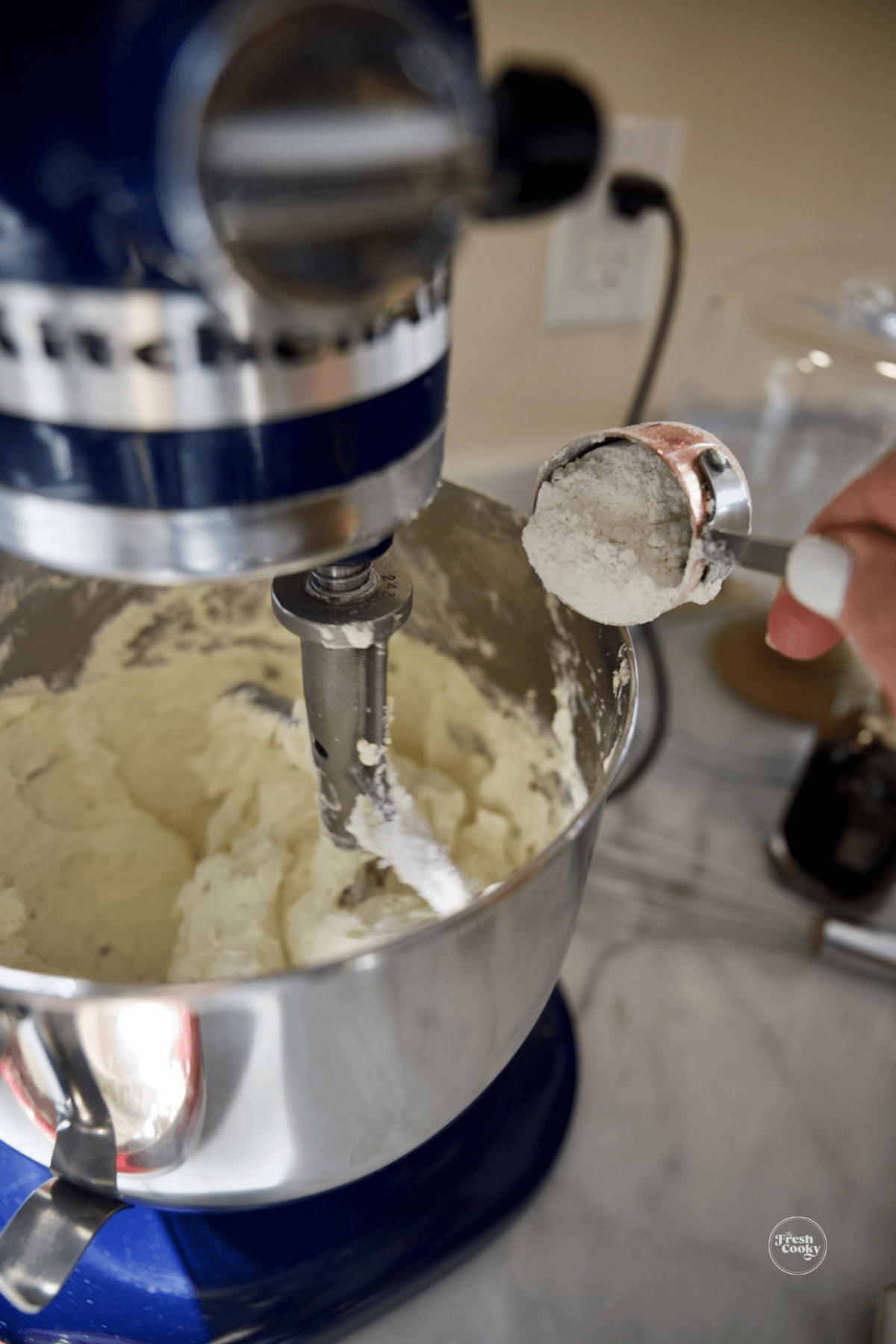 Slowly adding flour into dough mixture. 