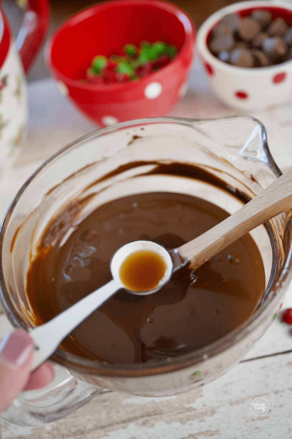 Adding vanilla extract to chocolate peanut butter mixture. 