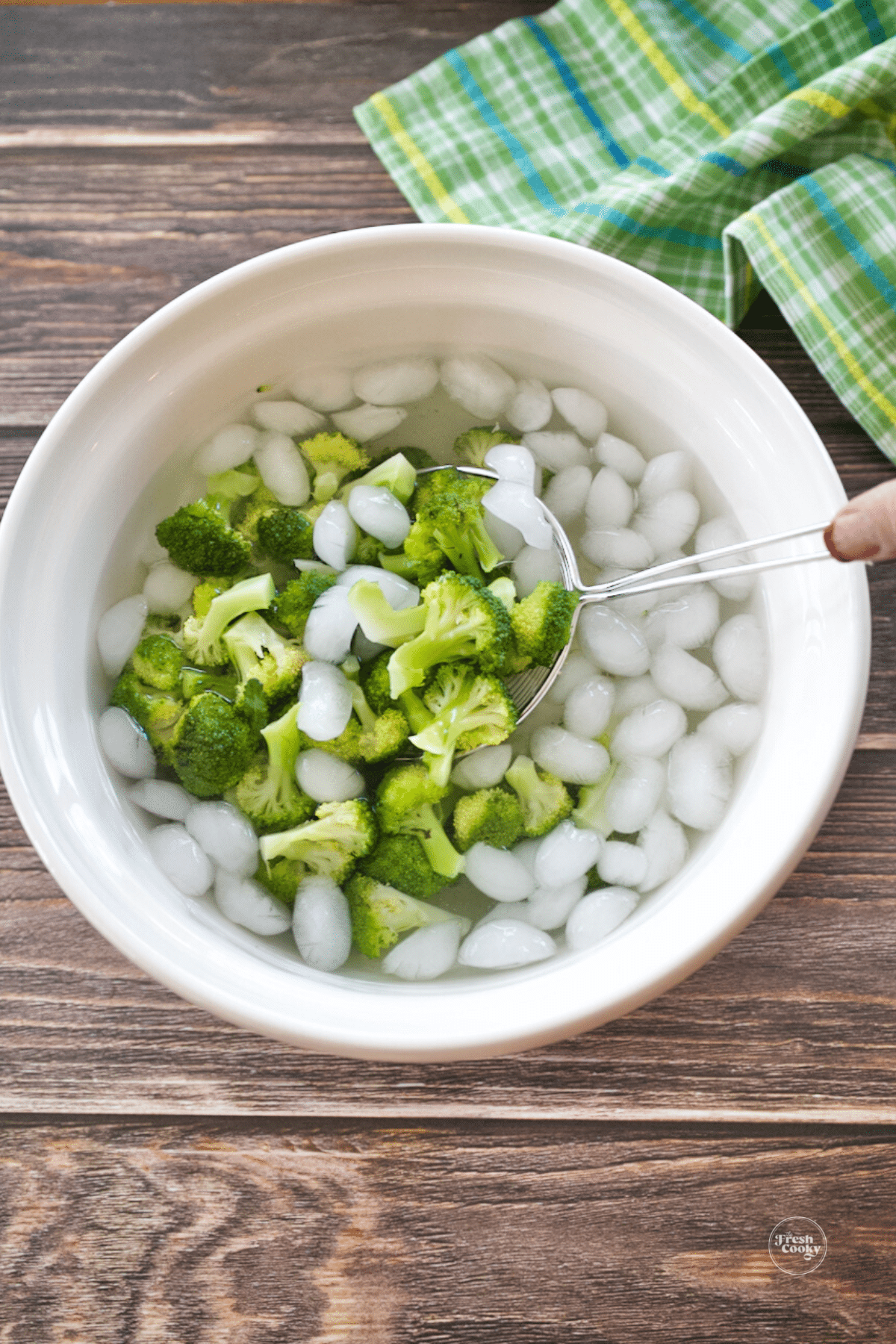 Plunging broccoli into ice water bath to stop cooking.