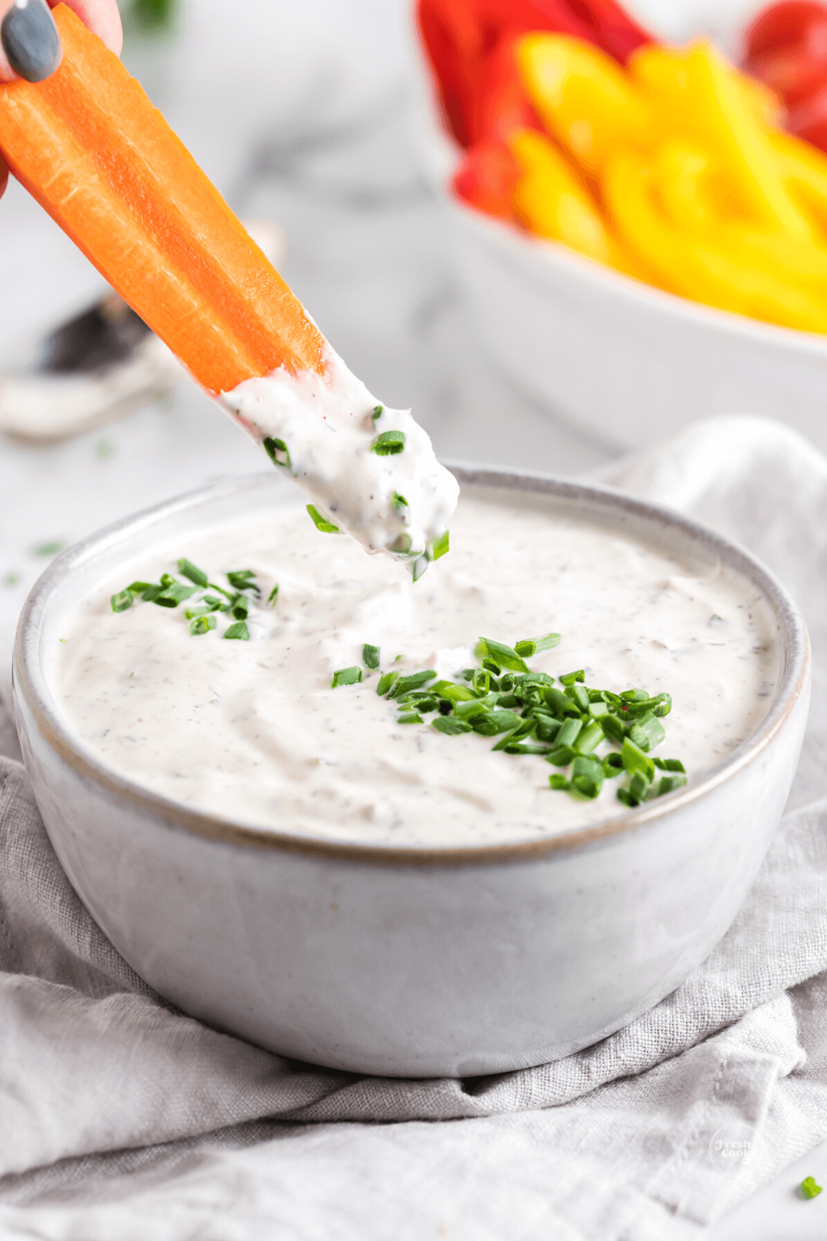 Carrot stick being dipped into the best veggie dip.