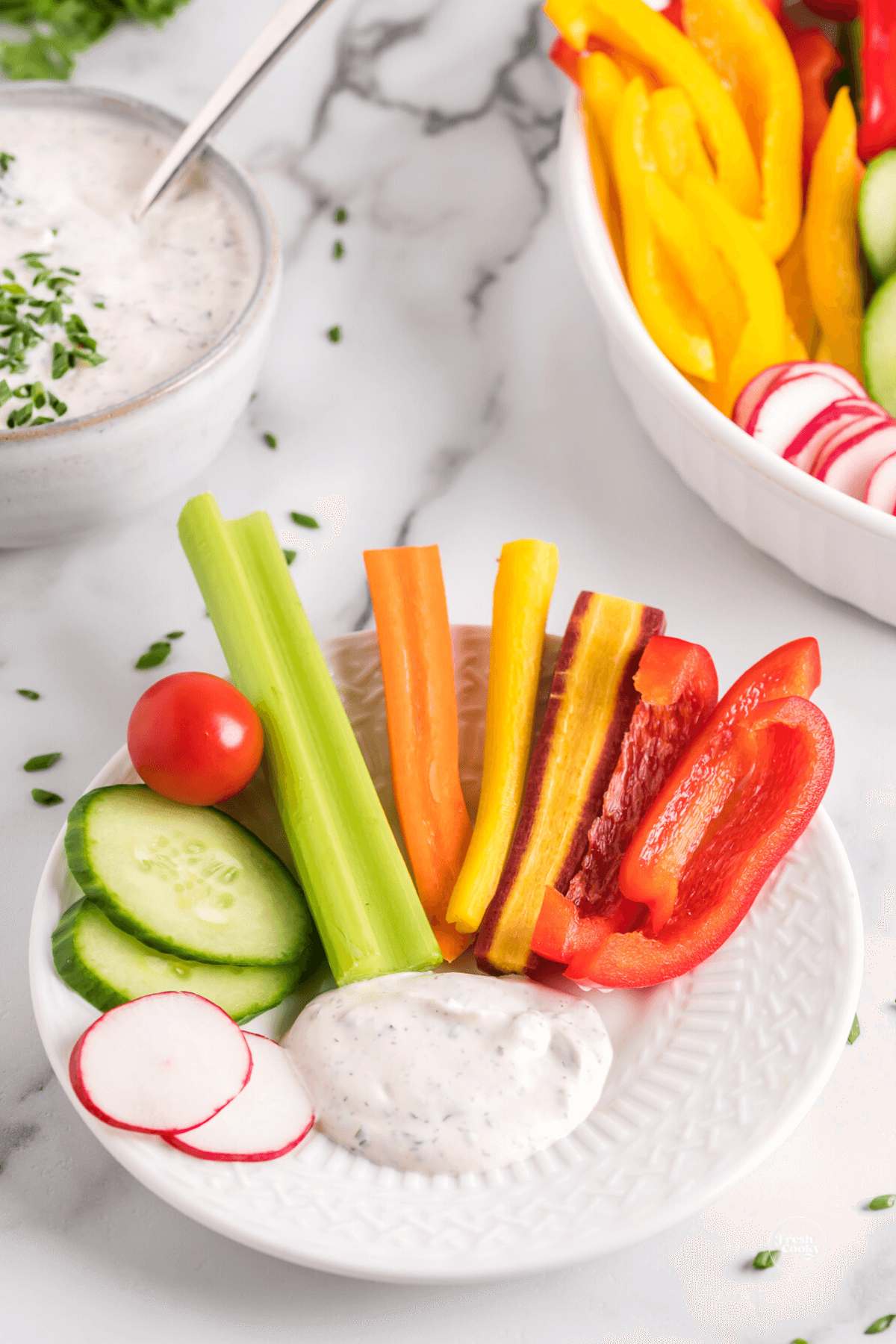 Crudite veggies on plate with spoonful of veggie dip.