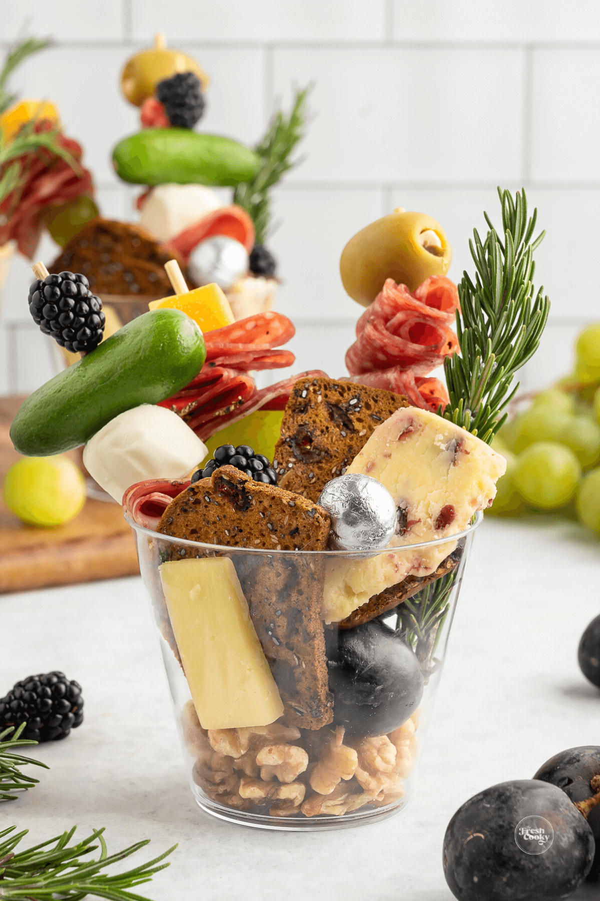 Beautiful charcuterie cup filled with three skewers of goodies, along with crackers, cheeses and chocolate.