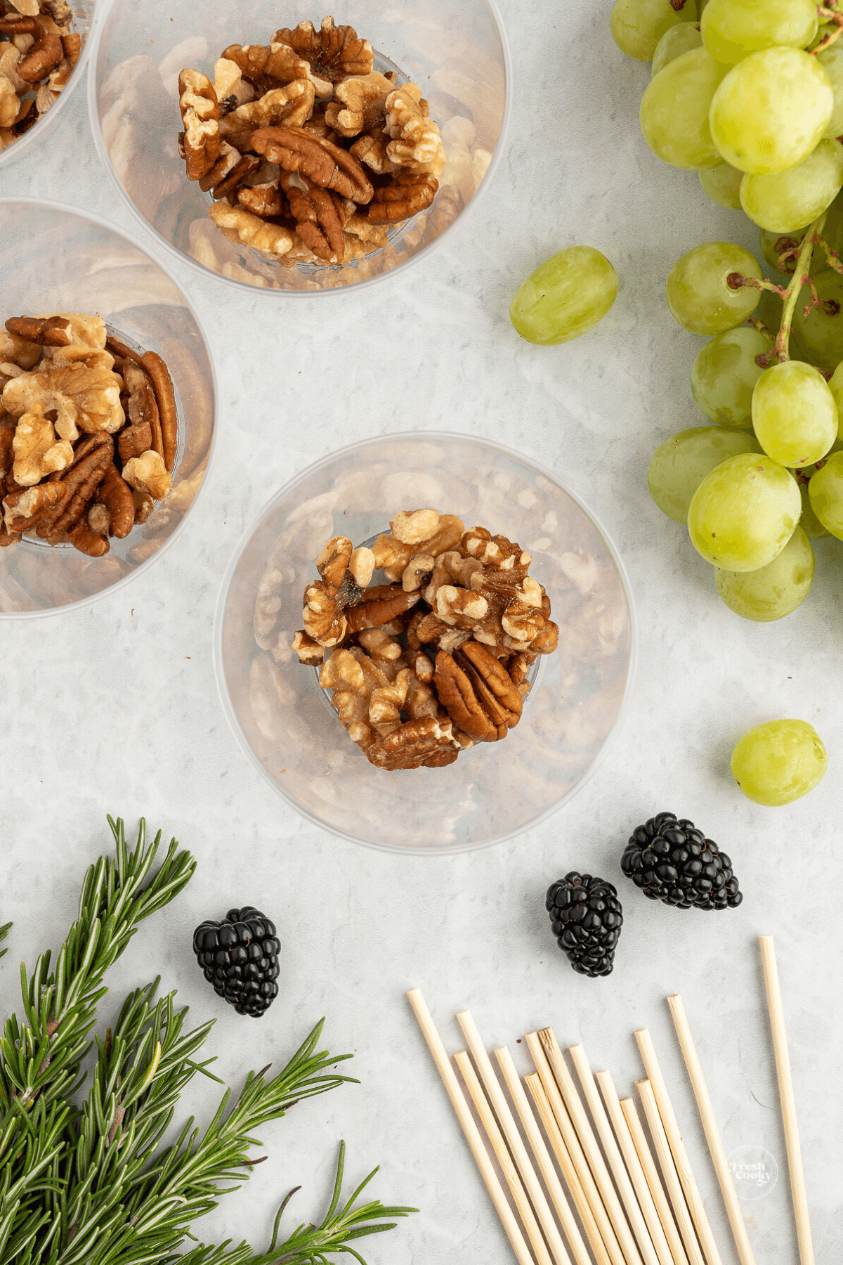 Adding nuts to the base layer of a charcuterie cup.