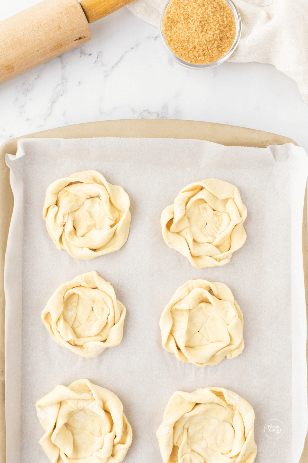 Puff pastry nests on baking sheet with parchment paper.