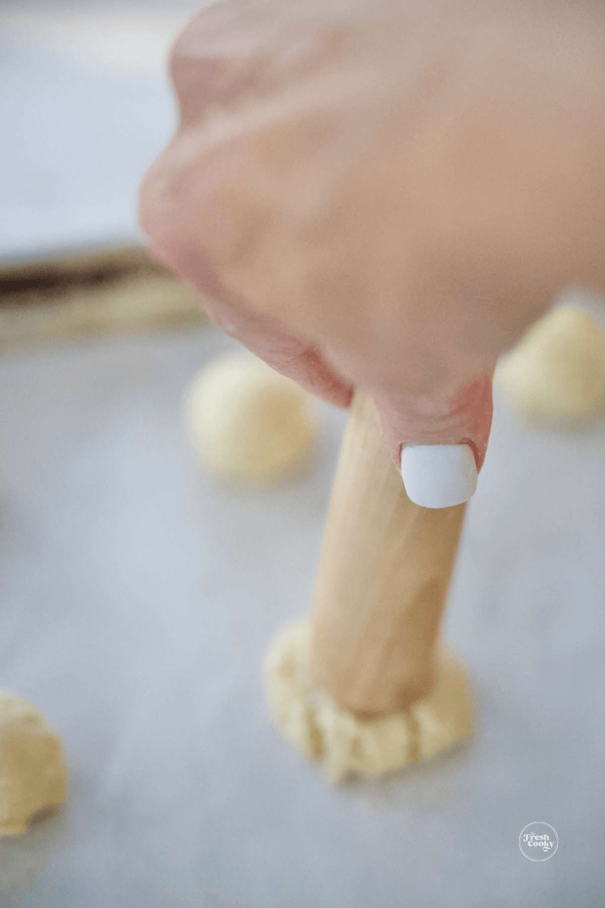 Using a muddler to press indent into cookie dough. 