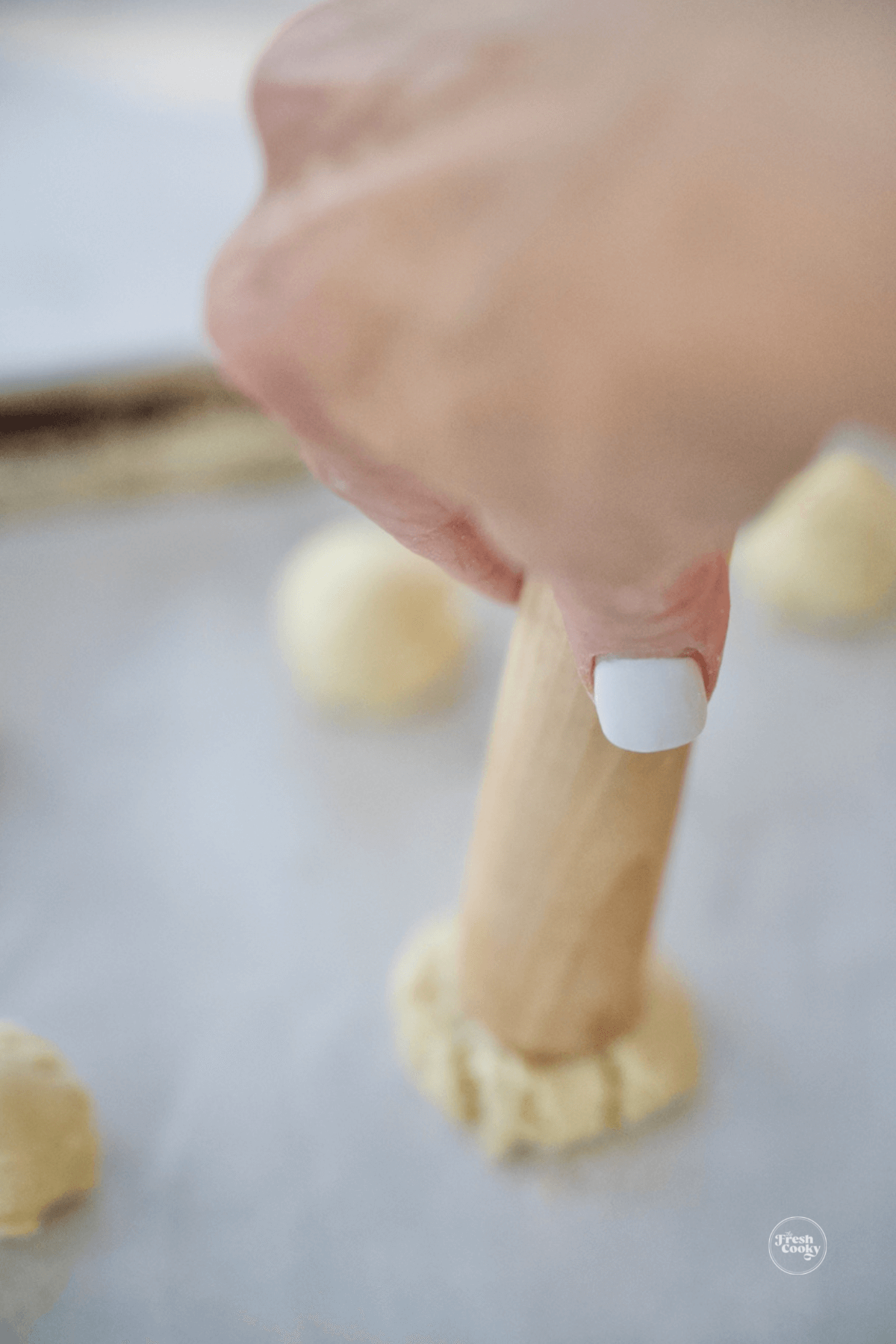 Using a muddler to press indent into cookie dough.