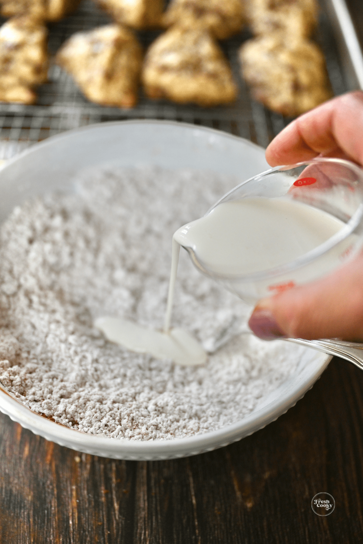 Pouring cream into glaze ingredients for scones. 