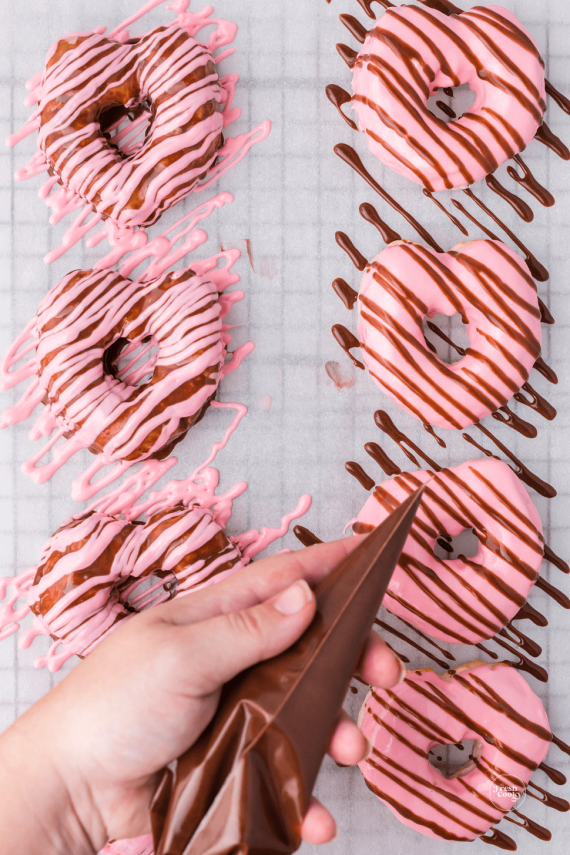 Add frosting to piping bag, decorate donuts. 