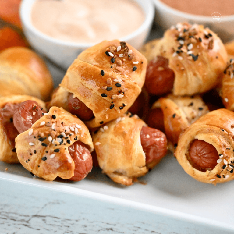 Air fryer pigs in a blanket on a plate with sauces.