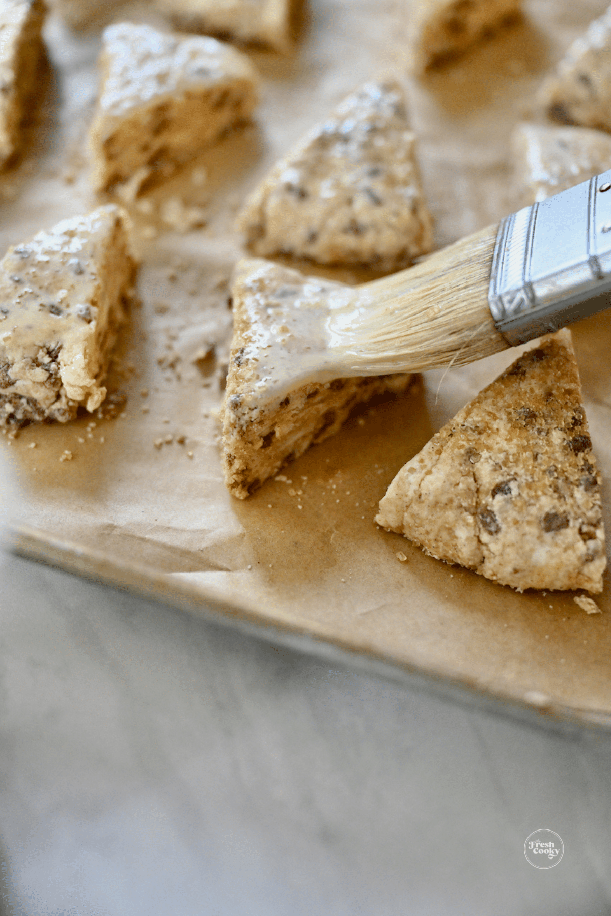 Brushing scones with egg and cream wash before baking. 
