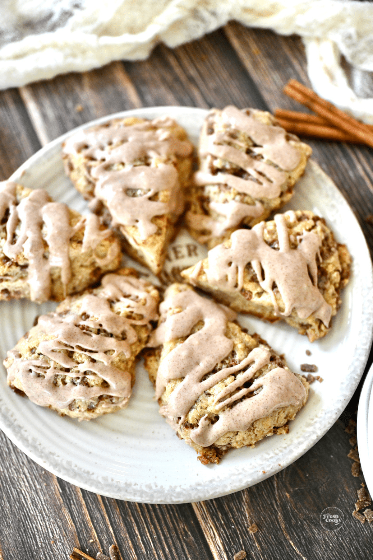 Scones on a plate drizzled with cinnamon glaze.