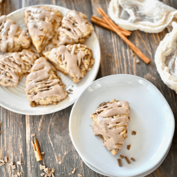 Cinnamon chip scones on a plate for serving, with one scone on a single plate.