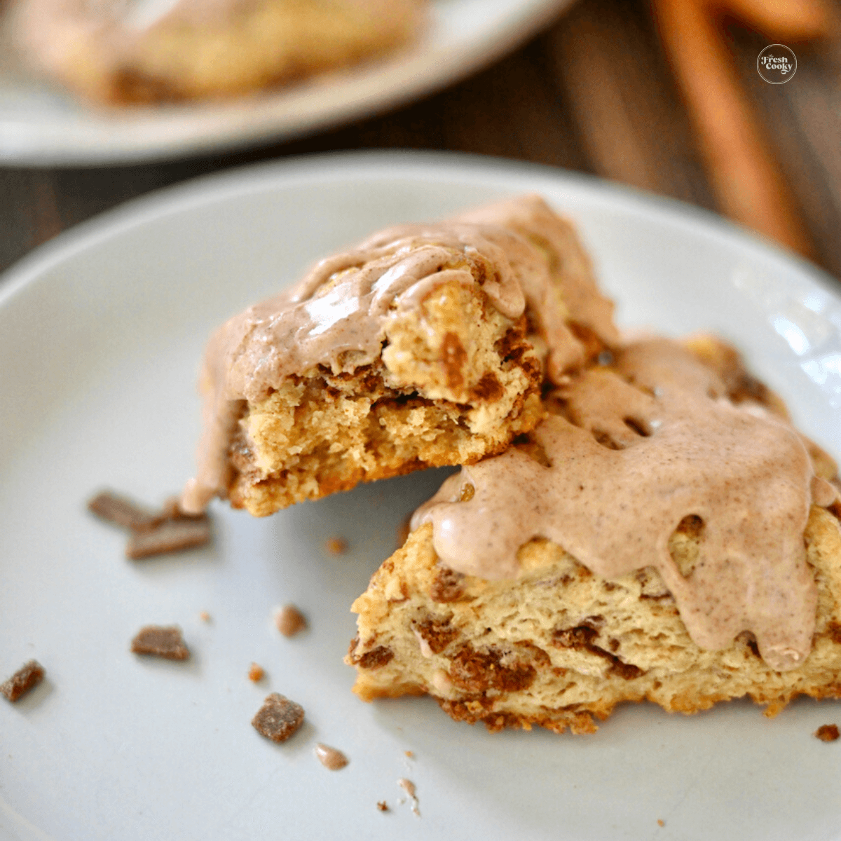 Cinnamon chip scones on plate one with bite taken out.