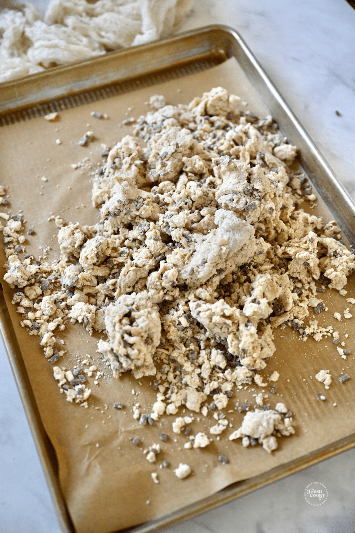Crumbly cinnamon chip scones dough on baking sheet with parchment paper. 