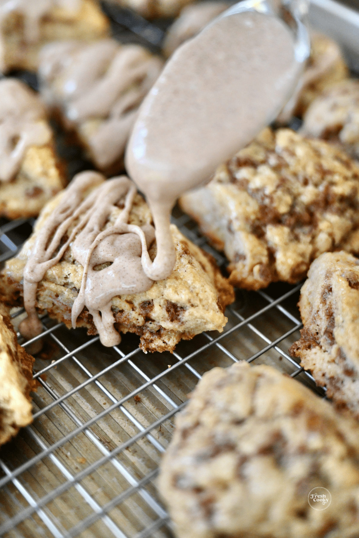 Drizzling cinnamon glaze on top of cinnamon chip scones.